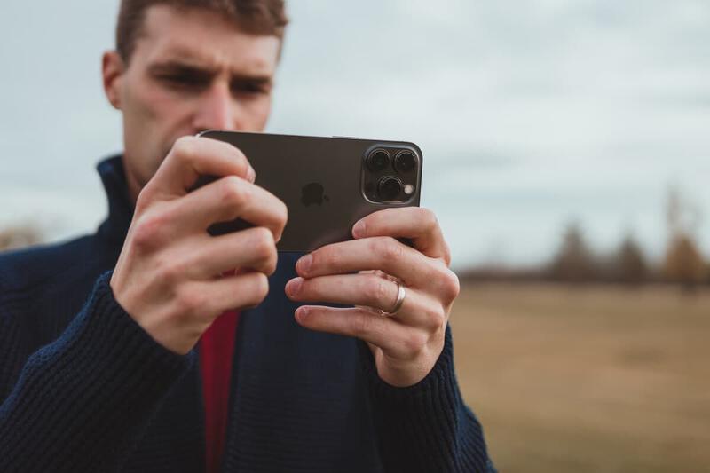 A user holds an iPhone 13 Pro to capture content, highlighting the device